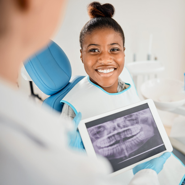 Woman, dentist and happy with dental xray or results in clinic with satisfaction for teeth treatment with doctor. Female patient, dentist and smile in consultation with canal procedure for oral care