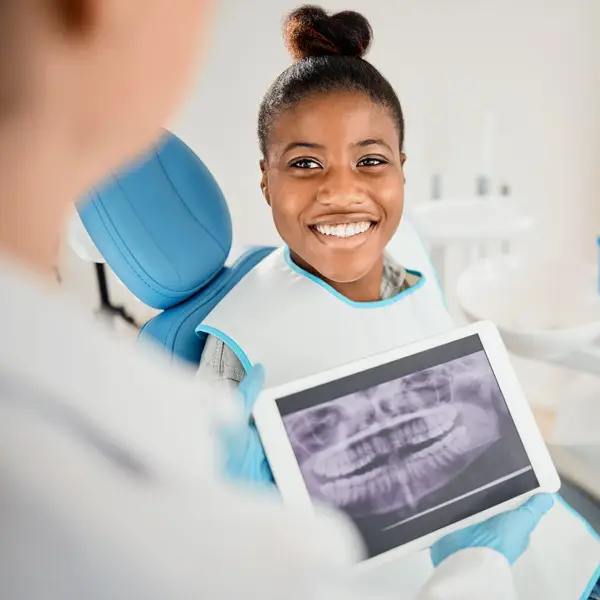 Woman, dentist and happy with dental xray or results in clinic with satisfaction for teeth treatment with doctor. Female patient, dentist and smile in consultation with canal procedure for oral care